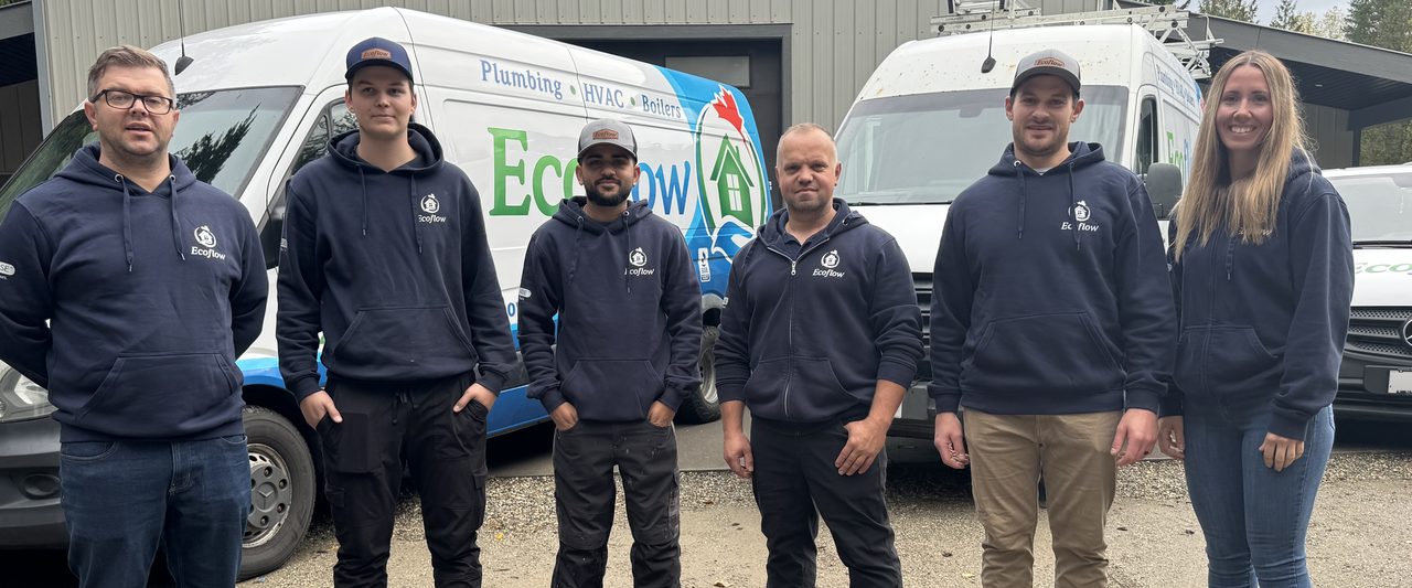The Ecoflow team, Paul, Jason, Harman, Sergei, Adam and Cassie, standing in front of two Ecoflow vans outside the shop.