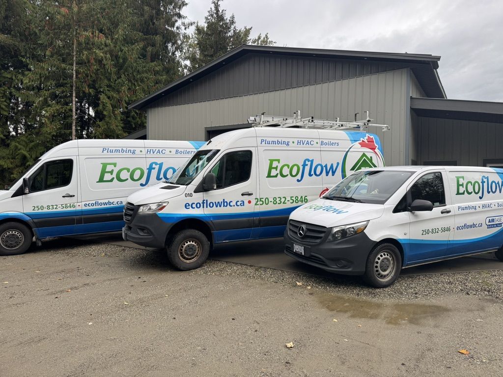 Three Ecoflow service vans parked in front of the shop, lettered for plumbing, HVAC, and boilers.